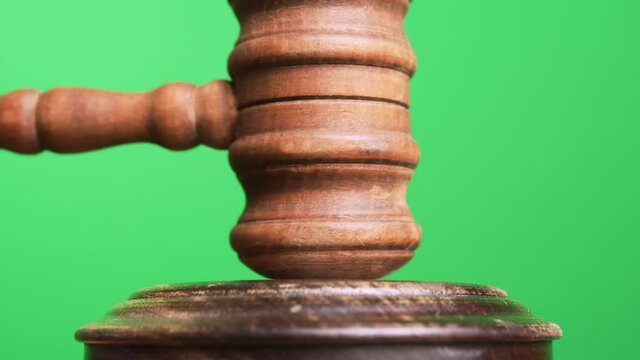 Gavel being struck to decide an auction or guilty verdict in court. Green Screen. Medium and wide shot with Alpha channel Black and white included.