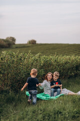 Big young happy family in the field on the nature. Mom, dad and 2 sons are having fun, running, fooling around together. Happiness and smiles around