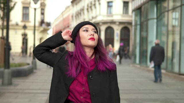 Portrait of elegant asian girl wearing stylish black coat, red shirt, and attractive black cap. Attractive fashionable young woman walking in a beautiful street. Concept of vogue and hipster lifestyle