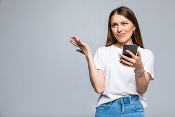 Disappointed confused woman using smartphone isolated on a white background