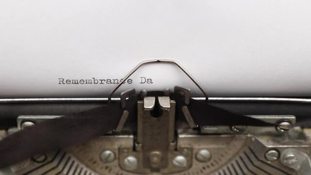 Typing a phrase Remembrance Day on a vintage typewriter close-up. concept of festive banner for national holiday
