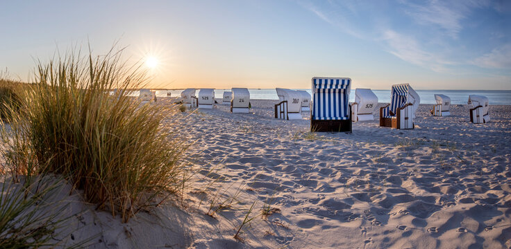 Canopied beach chairs at beach near Prerow (Dar&szlig; Peninsula, Germany) in evening light
