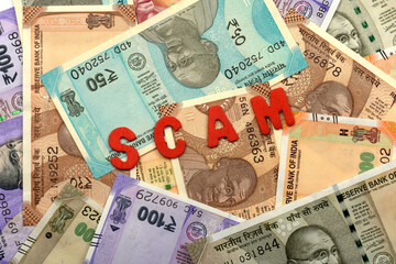 Scam and money concept,Scam red alphabets on money background,Indian Currency, Rupee, Indian Rupee,Indian Money, Business, finance, investment, saving and corruption concept
