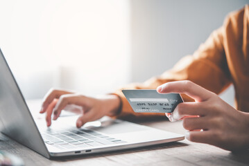 Woman's hand holding a credit card and working on laptop. Online payment for online shopping