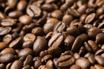 Roasted coffee beans background - full frame detail. Close up of a brown surface texture of aroma black caffeine drink ingredient for coffee beverage