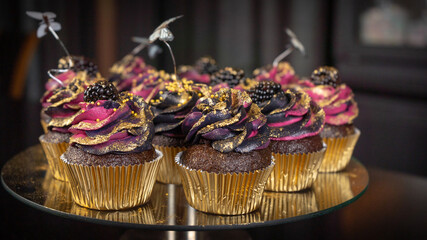 Glamorous black and pink cupcakes on dark background.