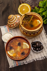 Hodgepodge, hot soup served in traditional ceramic bowl and pot. Classical Eastern Europe dish