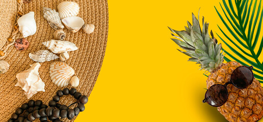 Summer abstract marine background for travel. Pineapple with glasses, a summer hat, palm branches. Banner, close-up.