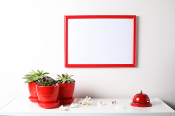 Red and white frame poster with plant in pot on table.