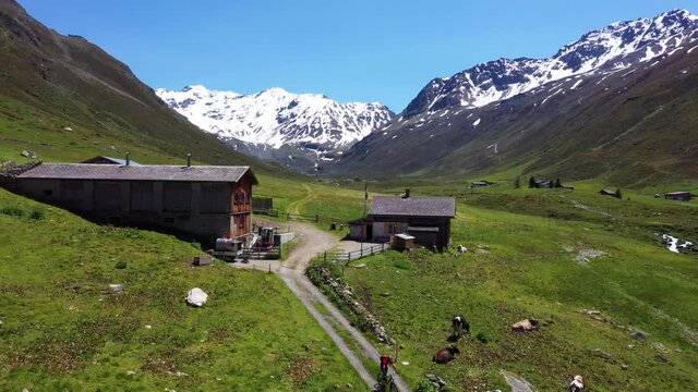 Aerial view of man riding down a trail at the swiss alps in summer.