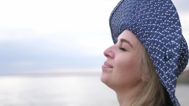 Happy Blond Beautiful Girl in hat Relaxing On Vacation Beach. Close up of face