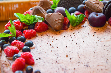 Chocolate cake in cocoa from above berries raspberries, black currant, biscuits, sweets on a round plate on the table. Cake slice, berries in macro. Birthday cake number 2. Top view, side view. 