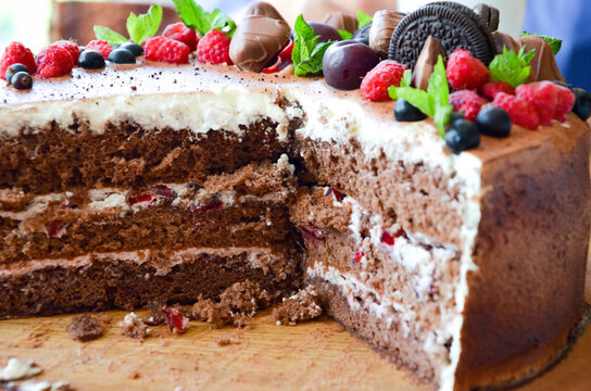 Chocolate Cake In Cocoa From Above Berries Raspberries, Black Currant, Biscuits, Sweets On A Round Plate On The Table. Cake Slice, Berries In Macro. Birthday Cake Number 2. Top View, Side View. 