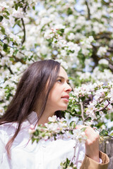 Fototapeta premium girl in the flowers of the apple tree