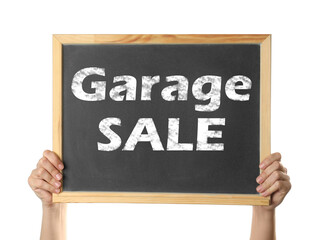 Woman holding blackboard with phrase GARAGE SALE on white background, closeup