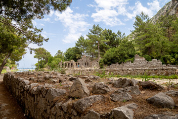 Fototapeta na wymiar Ruins of the ancient city of Olympos in Cirali village in Antalya, Turkey. Local and foreign tourists come to visit the ancient city and swim.