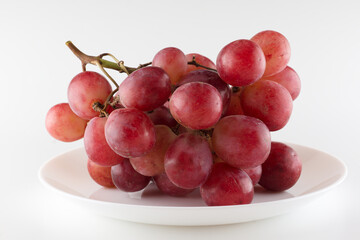 bunch of fresh grapes lies on a dinner plate