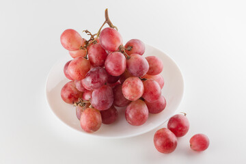 bunch of fresh grapes lies on a dinner plate