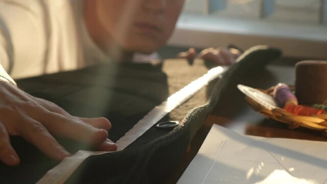 Tailor or clothing designer works with fabric, close-up