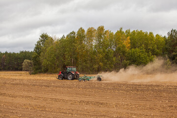 Farmer in tractor preparing farmland with seedbed for the next year