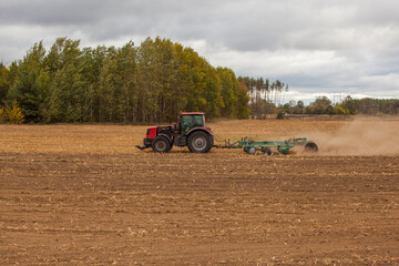 Farmer in tractor preparing farmland with seedbed for the next year