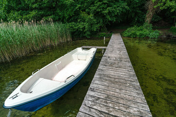 A blue and white boat at an old wooden landing stage