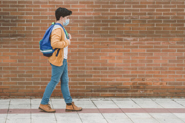 Fototapeta na wymiar kid with medical mask and backpack going to school