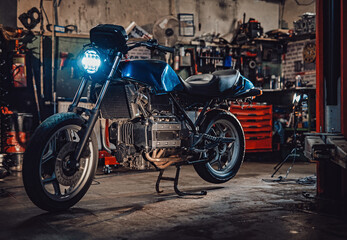 Fototapeta na wymiar Custom bobber motorcycle with front light on in workshop or garage