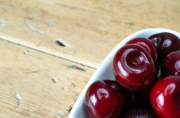 Cherries in a Heart shaped bowl on an Oak table top