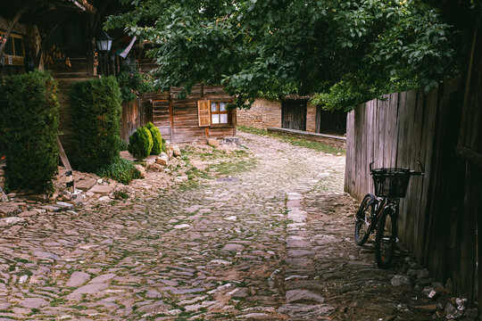 Leaning bicycle on cobbled street of old Bulgarian revival village of Zheravna, Balkan mountains