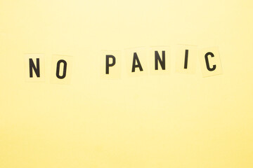 The inscription no panic on a yellow background close-up.