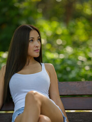 Naklejka premium Portrait of beautiful Asian woman sitting and thinking at the park outdoors