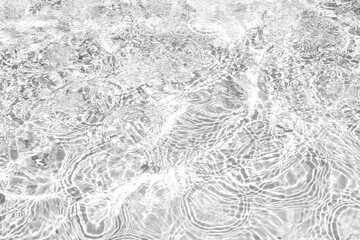 Closeup of desaturated transparent clear calm water surface texture with splashes and bubbles. Trendy abstract nature background. White-grey water waves in sunlight.