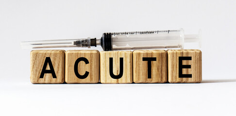 Text ACUTE made from wooden cubes. White background