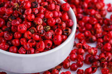 fragrant pink peppercorns on white acrylic background