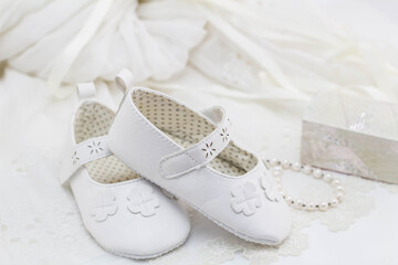 Baptism booties on lace with mother of pearl trinket box and pearl bracelet and de-focused...
