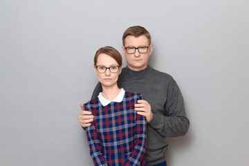 Portrait of man and woman with serious expressions and with glasses