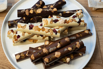 Three types of chocolate with dried fruits on the white background. Macro close of french chocolate. Fresh organic nut.
