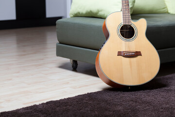 Acoustic electric guitar with tree of life inlay leaning on a couch in home studio ambient with...
