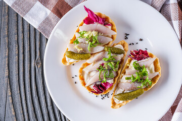 delicious snack tartlets on rustic wooden background