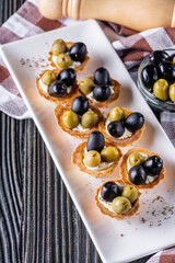 delicious snack tartlets on rustic wooden background