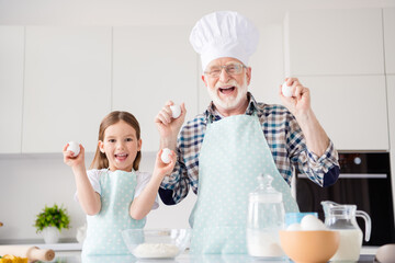 Photo of little girl granddaughter aged funny grandpa baking cookies together prepared ingredients...
