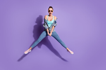 Fototapeta na wymiar Full length photo of astonished girl jump impressed unexpected unbelievable discounts wear singlet sneakers isolated over purple color background