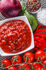 Fresh tasty tomato sauce on rustic wooden background