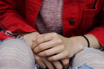 Close up details of  beautiful hands wearing jewelry.
Woman's hands resting on knees. Feeling...