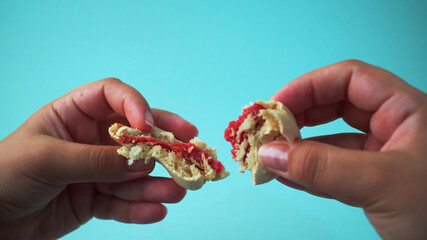Hands of a woman close up breaking a macaroon cake