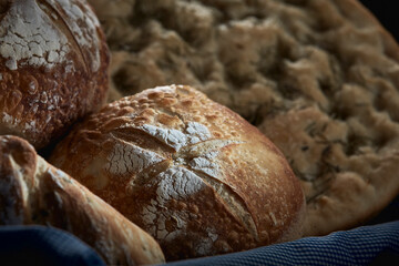 tasty rustic breads served in basket on dark background