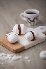 delicious meringues with dulce de leche served on a marble and wooden board accompanied by coffee
