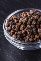 aromatic black pepper on a dark stone background