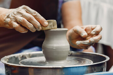 Potter make a small jug. Hands of a potter at work